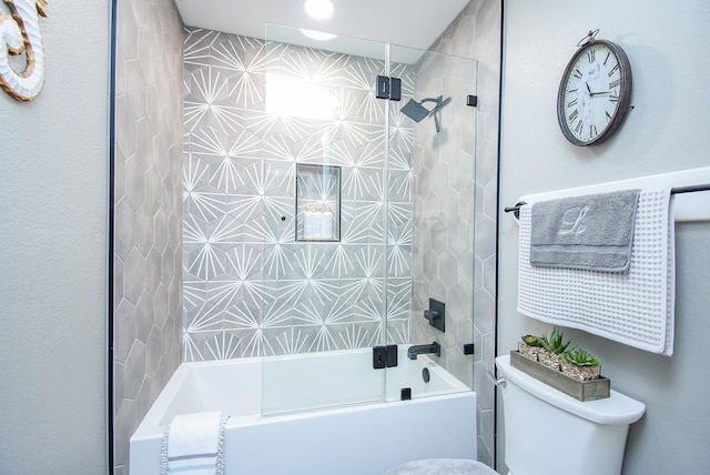 bathroom featuring bath / shower combo with glass door and toilet