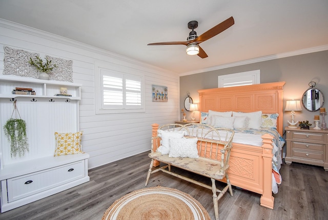 bedroom with crown molding, dark hardwood / wood-style floors, ceiling fan, and wood walls