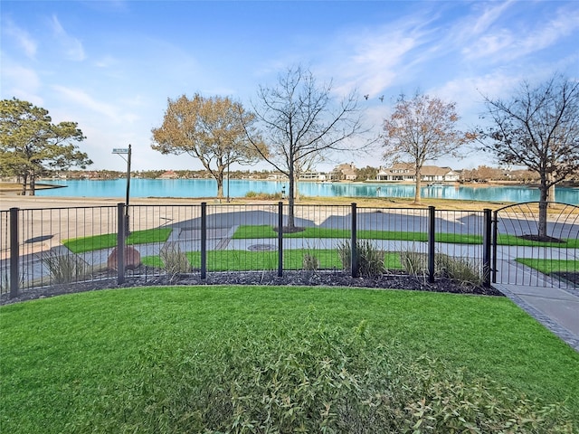 view of pool featuring a water view and a lawn