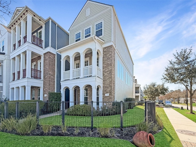 view of front of home featuring a balcony and a front lawn