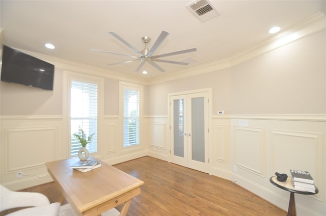 interior space with hardwood / wood-style floors, ceiling fan, and ornamental molding