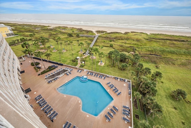 view of swimming pool featuring a water view and a beach view