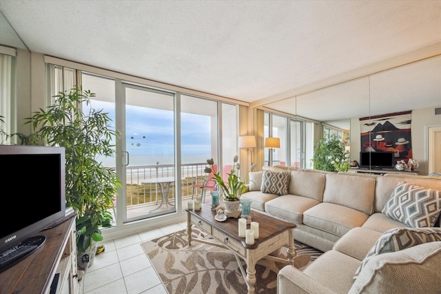 living room featuring a wall of windows, a textured ceiling, and light tile patterned floors