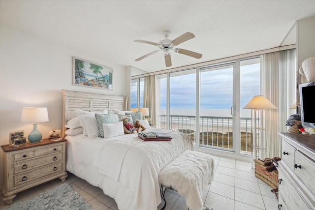 bedroom featuring multiple windows, floor to ceiling windows, light tile patterned floors, and ceiling fan