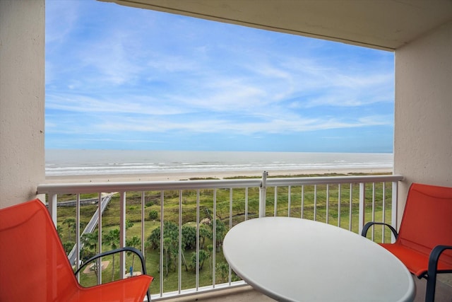 balcony with a water view and a view of the beach