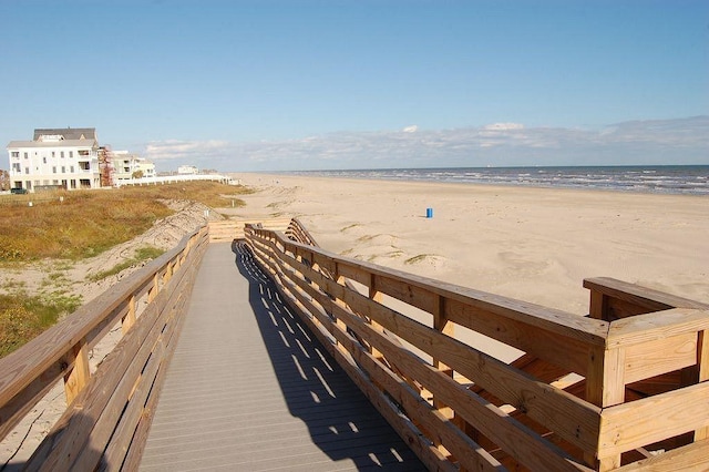 view of community with a water view and a beach view