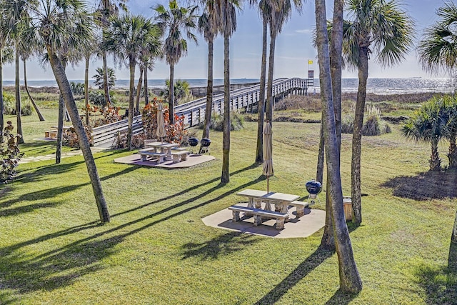 view of home's community featuring a water view, a yard, and a patio