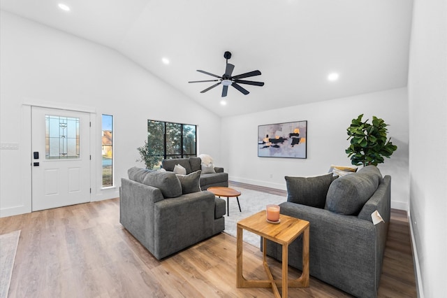 living room featuring light hardwood / wood-style flooring, high vaulted ceiling, and ceiling fan