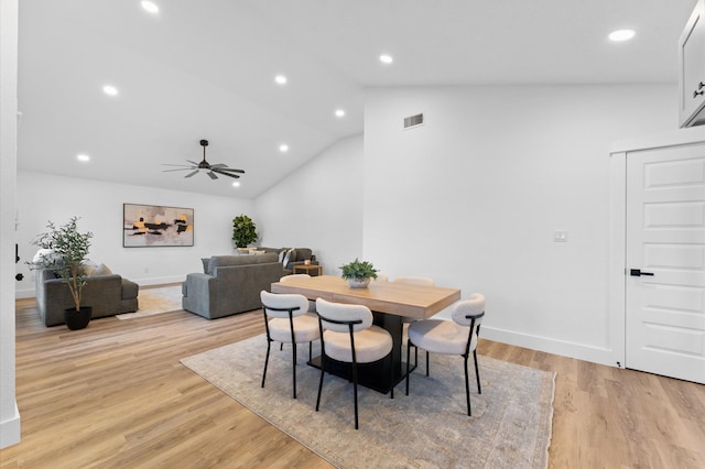 dining room with ceiling fan, vaulted ceiling, and light hardwood / wood-style flooring