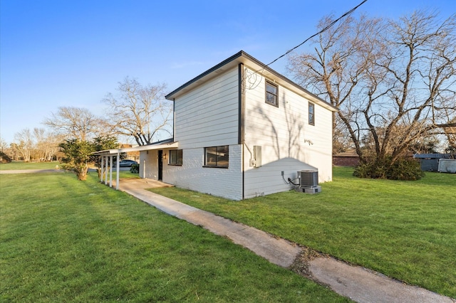 rear view of property featuring a lawn and central air condition unit