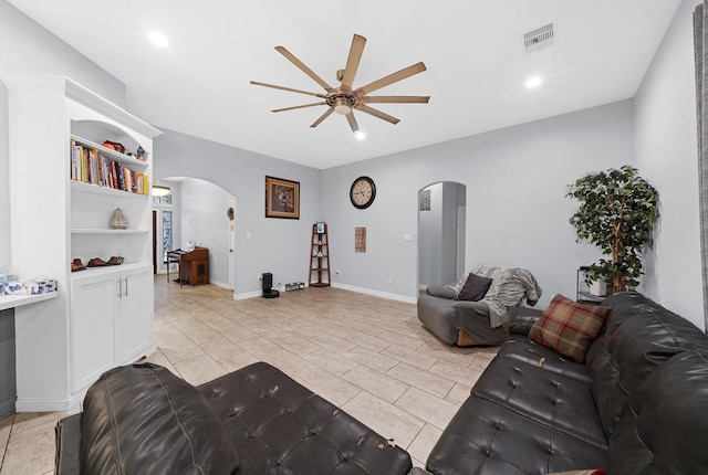 living room with light tile patterned flooring, ceiling fan, and built in shelves