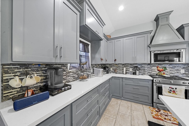 kitchen with premium range hood, stainless steel appliances, decorative backsplash, and light tile patterned floors