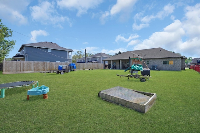 view of yard featuring a playground and a trampoline