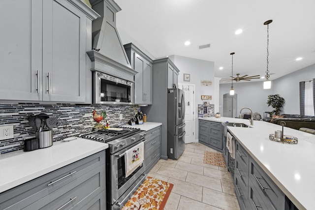 kitchen featuring light tile patterned floors, gray cabinetry, stainless steel appliances, tasteful backsplash, and decorative light fixtures