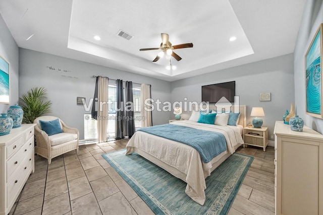 bedroom featuring ceiling fan and a tray ceiling