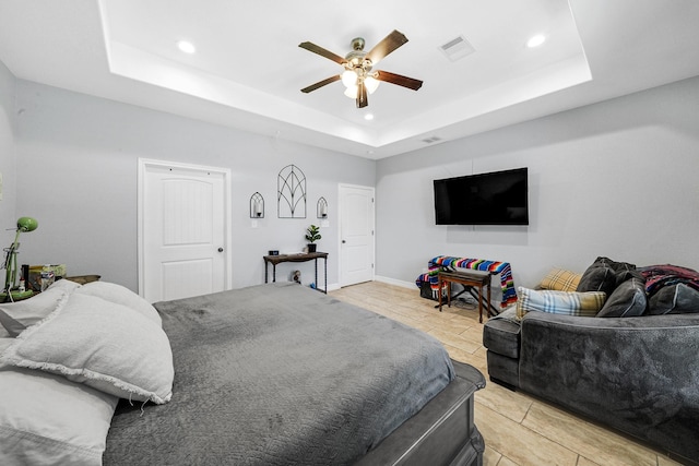 bedroom featuring light tile patterned floors, a tray ceiling, and ceiling fan