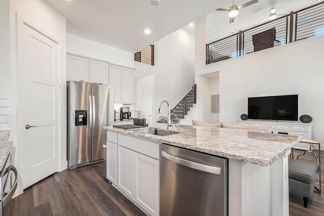 kitchen featuring stainless steel appliances, white cabinetry, a kitchen island with sink, and sink