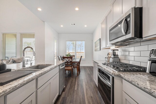 kitchen featuring sink, dark wood-type flooring, stainless steel appliances, and white cabinets