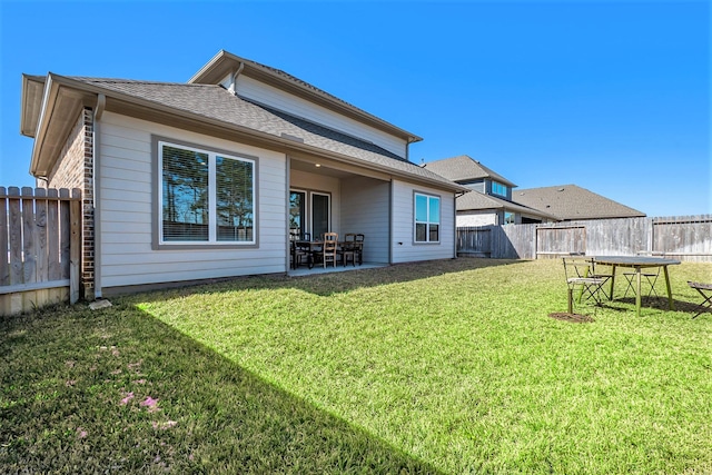 rear view of house featuring a yard and a patio