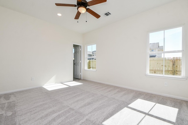 carpeted empty room with a healthy amount of sunlight and ceiling fan