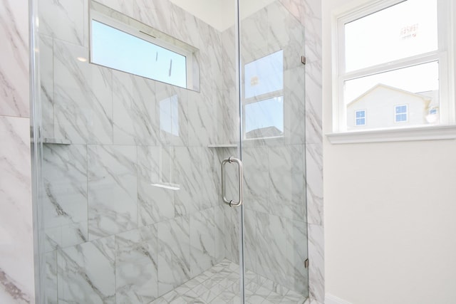 bathroom featuring plenty of natural light and a shower with shower door