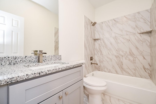 full bathroom featuring tiled shower / bath, vanity, and toilet