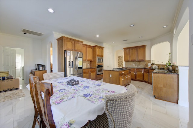 dining space featuring ornamental molding and sink