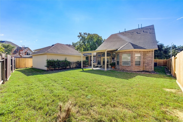 rear view of house featuring a patio and a yard