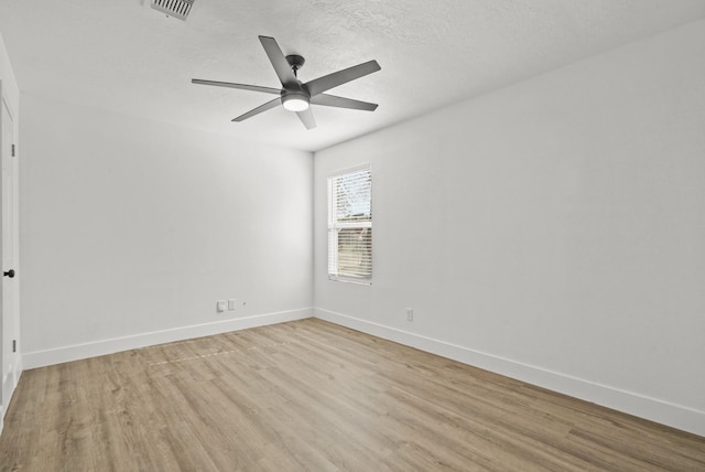 spare room featuring ceiling fan, light hardwood / wood-style floors, and a textured ceiling