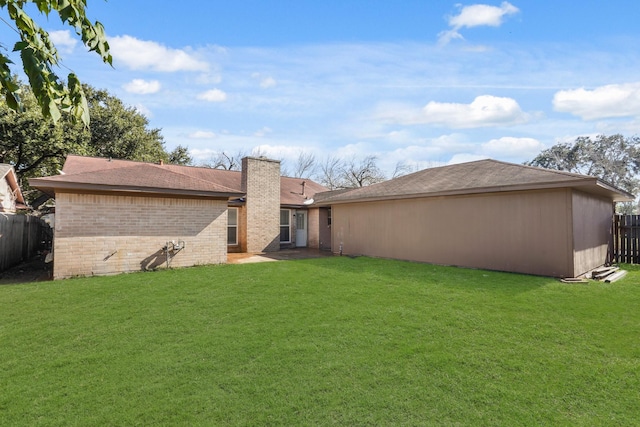 rear view of property featuring a lawn