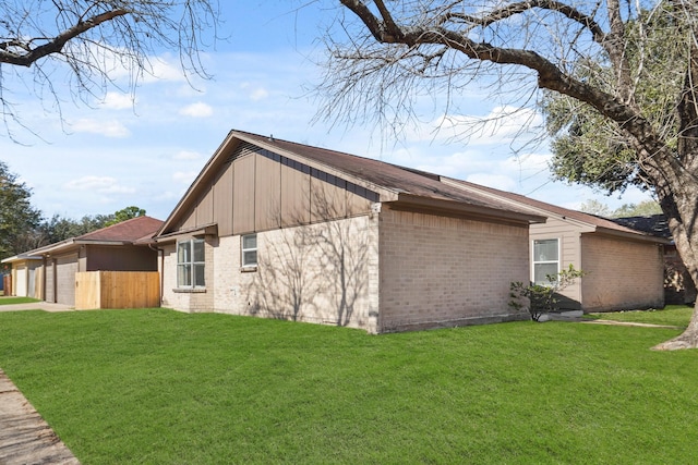 view of side of property featuring a garage and a lawn