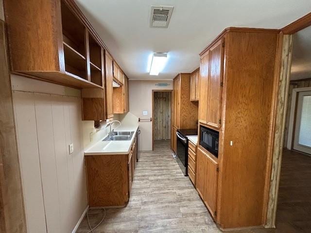 kitchen featuring light hardwood / wood-style floors, sink, and black appliances