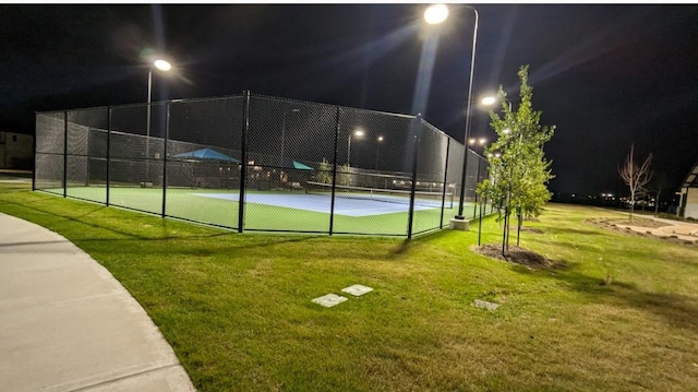 view of sport court featuring a lawn