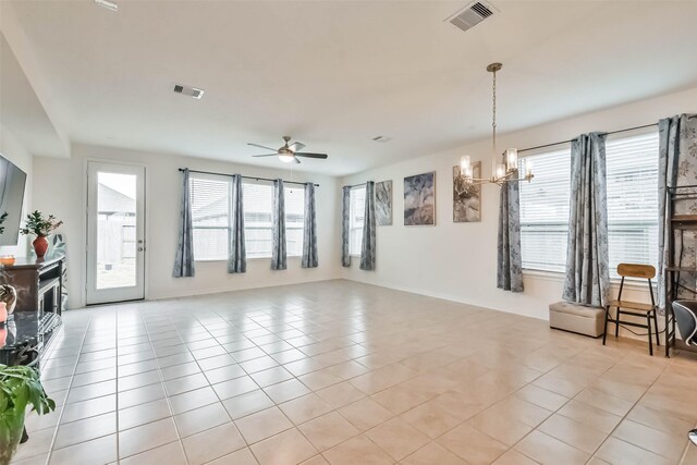 unfurnished living room featuring ceiling fan with notable chandelier and light tile patterned floors