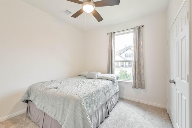 carpeted bedroom with ceiling fan and a closet