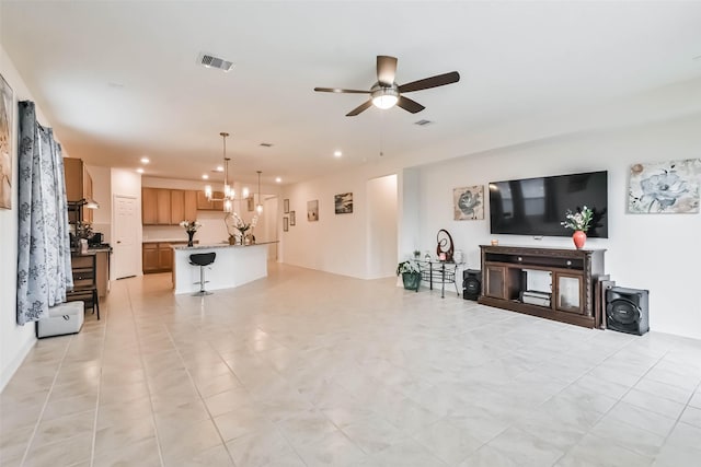 living room featuring ceiling fan with notable chandelier