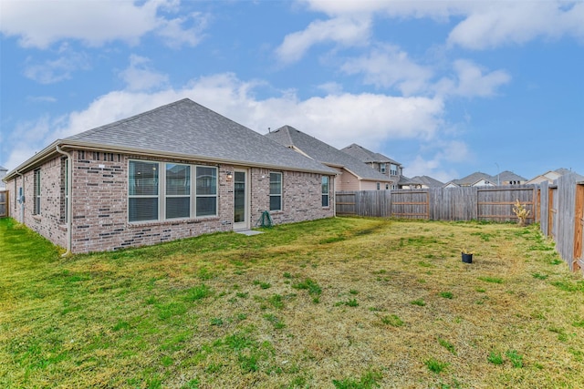 rear view of house featuring a yard