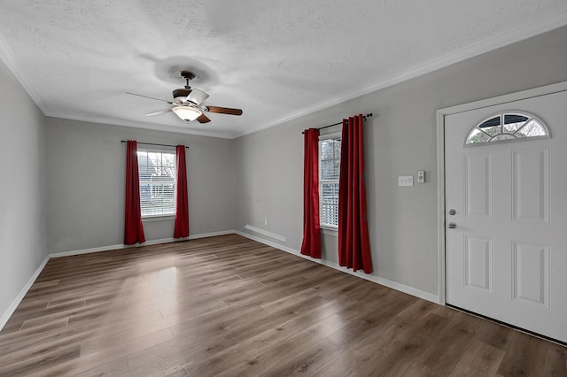 foyer entrance with crown molding, light hardwood / wood-style flooring, and a textured ceiling