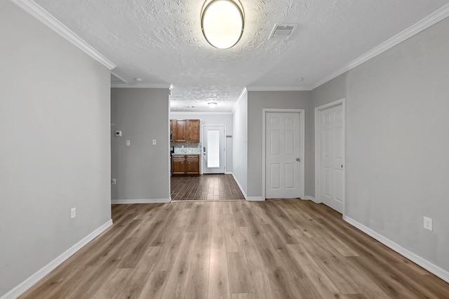 interior space featuring hardwood / wood-style flooring, ornamental molding, and a textured ceiling