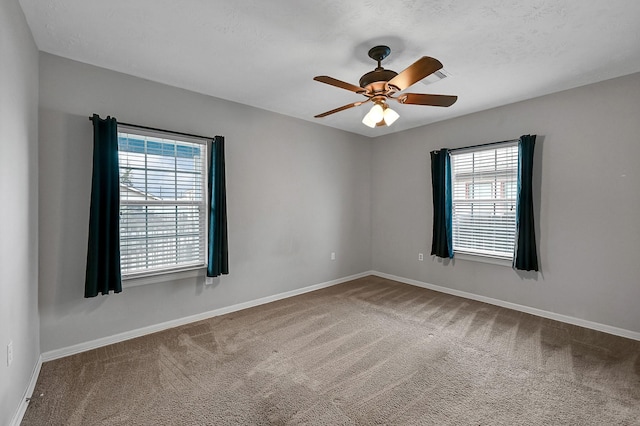 empty room featuring carpet, plenty of natural light, and ceiling fan