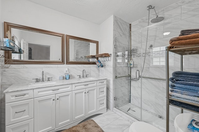 bathroom featuring tasteful backsplash, tile walls, vanity, walk in shower, and a textured ceiling