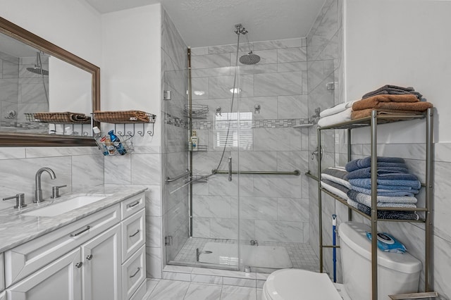 bathroom with tile walls, vanity, walk in shower, toilet, and a textured ceiling