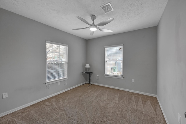 spare room featuring ceiling fan, a textured ceiling, and carpet flooring