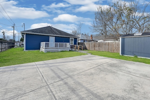 rear view of property featuring a yard and a deck