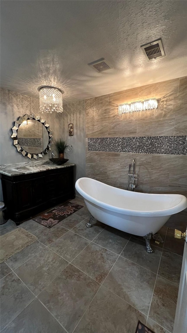 bathroom with tile walls, a textured ceiling, and a tub to relax in