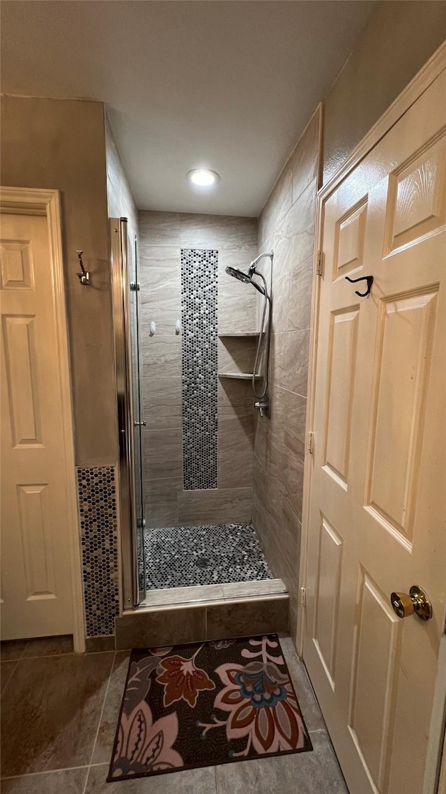 bathroom featuring a shower with shower door and tile patterned floors