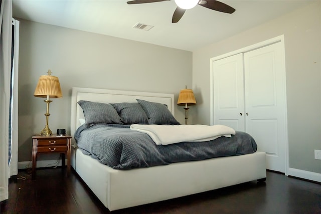 bedroom featuring dark wood-type flooring, ceiling fan, and a closet