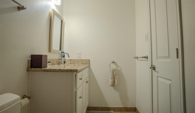 bathroom featuring vanity, tile patterned floors, and toilet