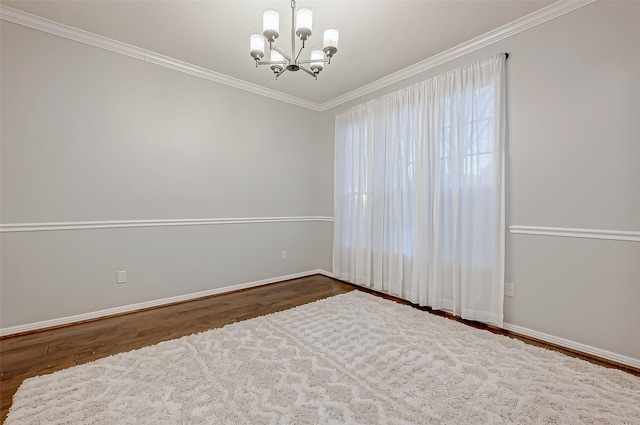 spare room featuring a notable chandelier, crown molding, and dark hardwood / wood-style floors