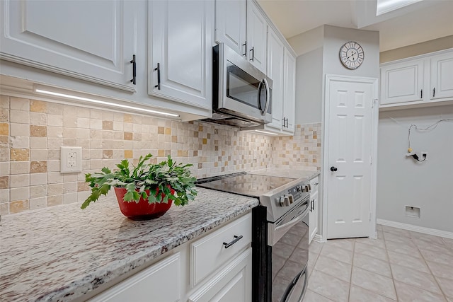 kitchen featuring backsplash, stainless steel appliances, white cabinets, and light tile patterned flooring